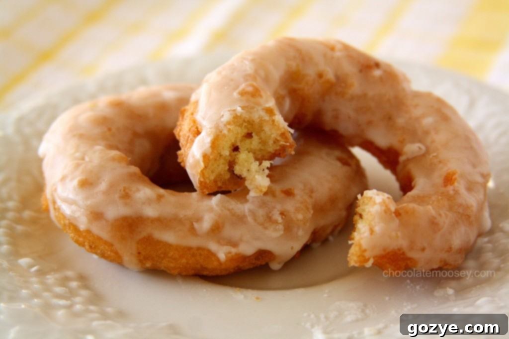 Double Lemon Glazed Doughnuts from www.chocolatemoosey.com A close-up of a double lemon glazed doughnut showing its fluffy texture