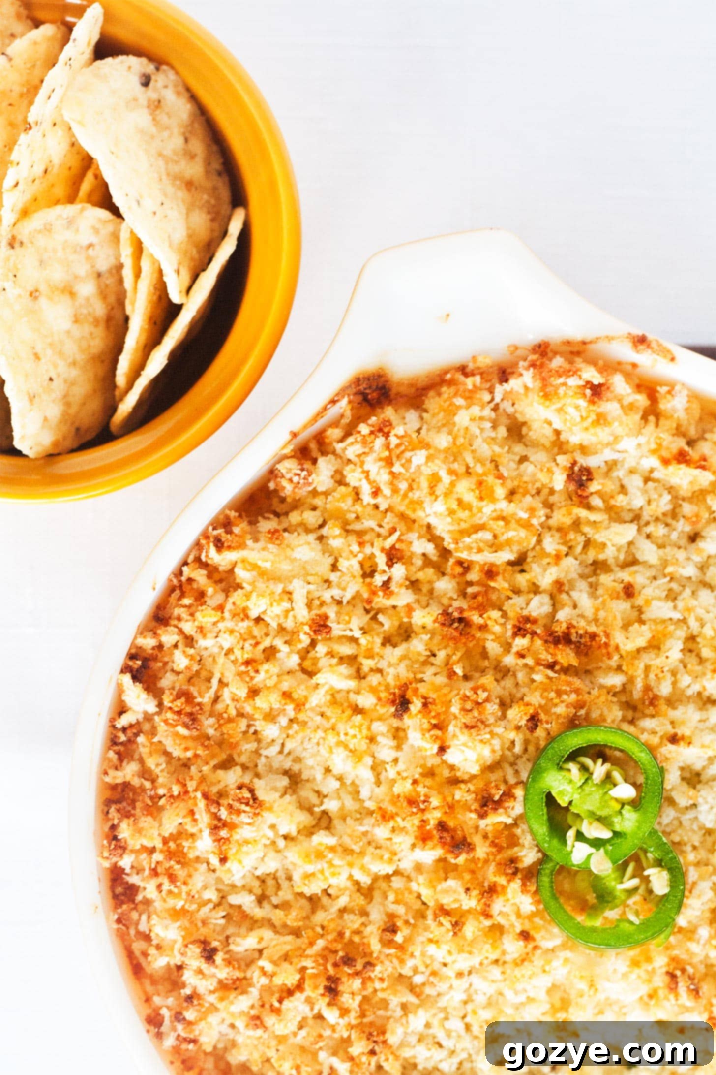 Close up overhead shot of jalapeno popper dip with nachos, ready for dipping.