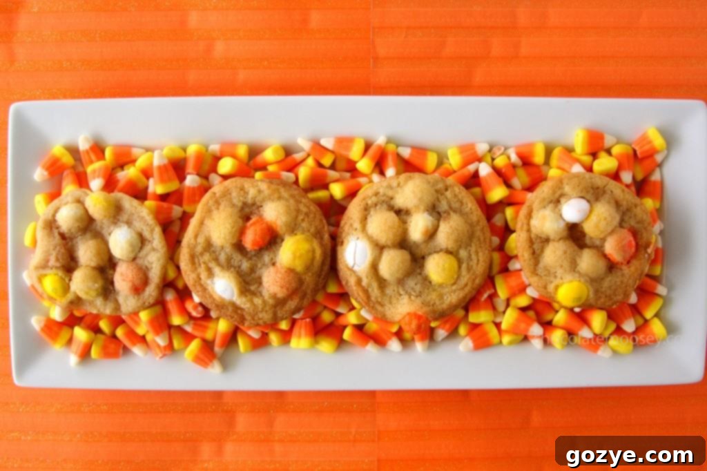 Freshly baked White Chocolate Candy Corn M&M Cookies cooling on a rack.