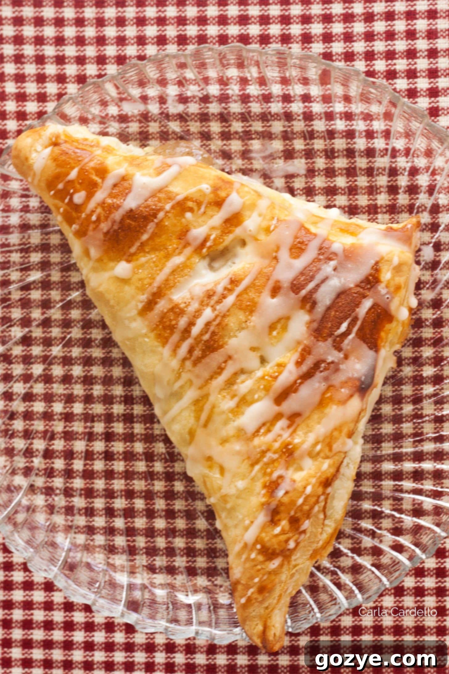 Single puff pastry apple turnover on a clear plate