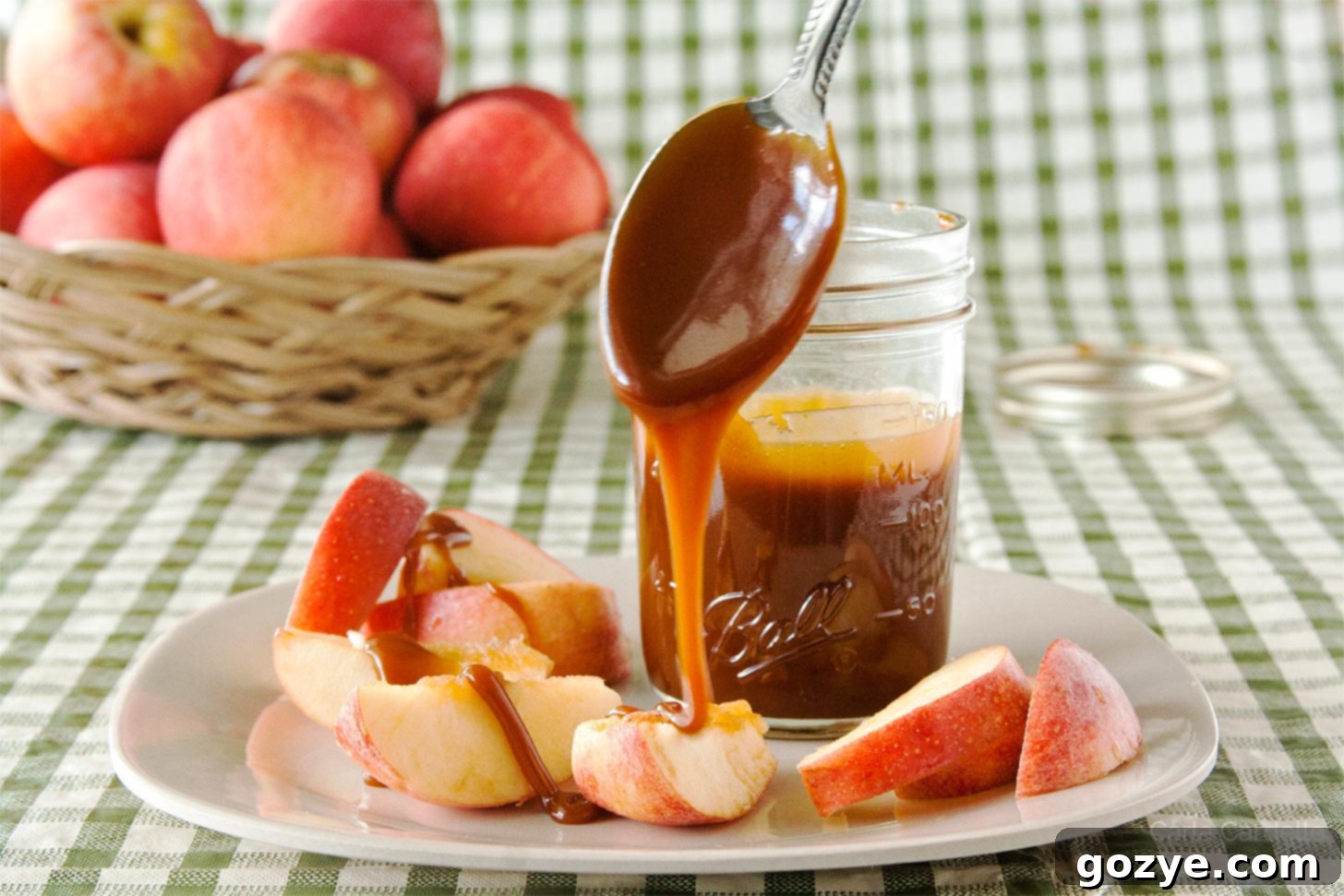 Caramel sauce dripping off spoon onto apple slices