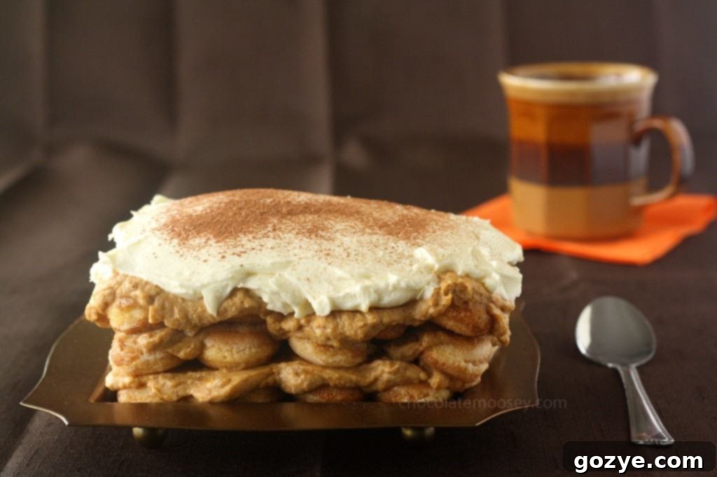 Close-up of a slice of Pumpkin Tiramisu revealing the distinct layers of spiced pumpkin cream and soaked ladyfingers.
