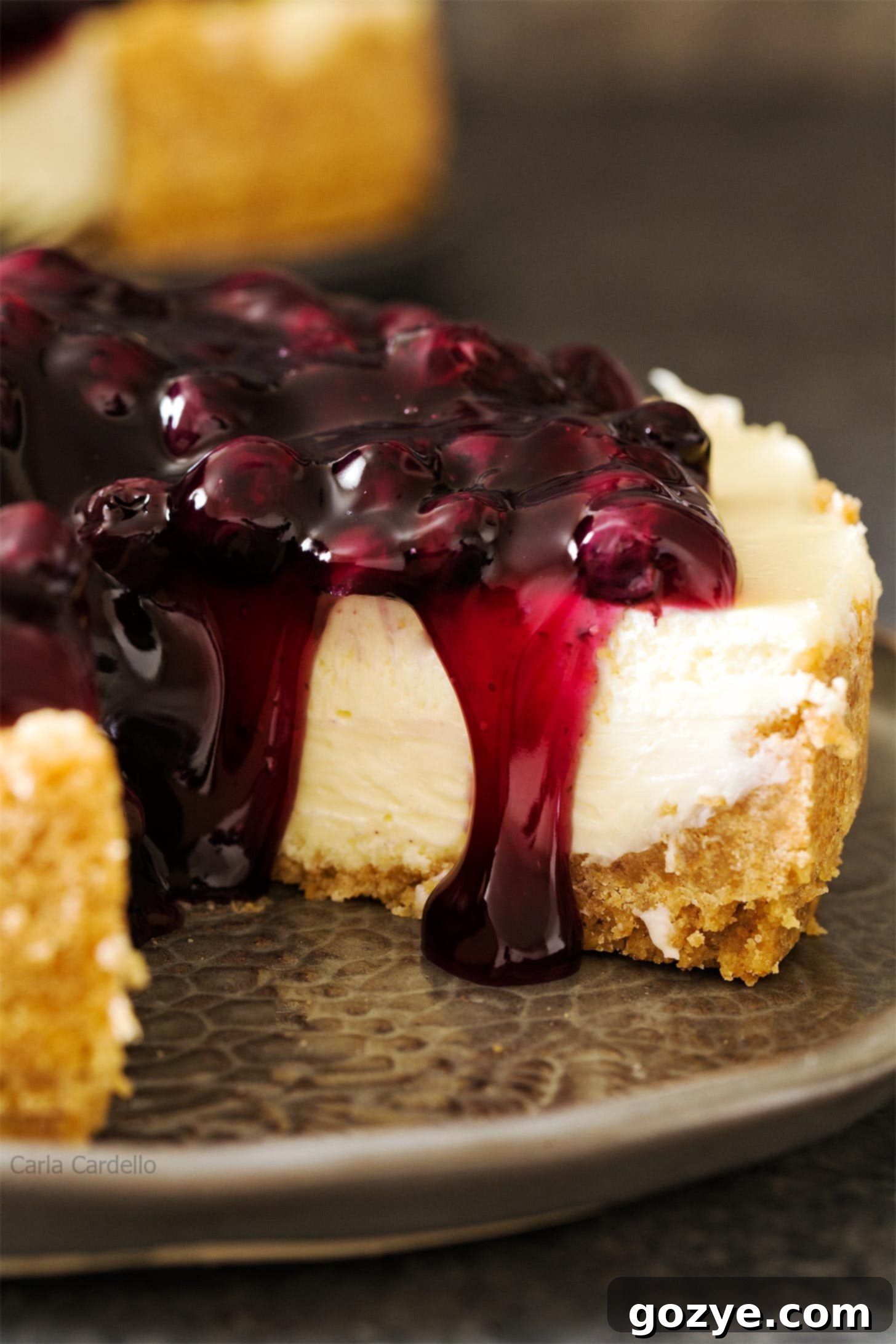 Close-up of a perfectly baked 7 inch cheesecake on a grey plate, showcasing its smooth texture