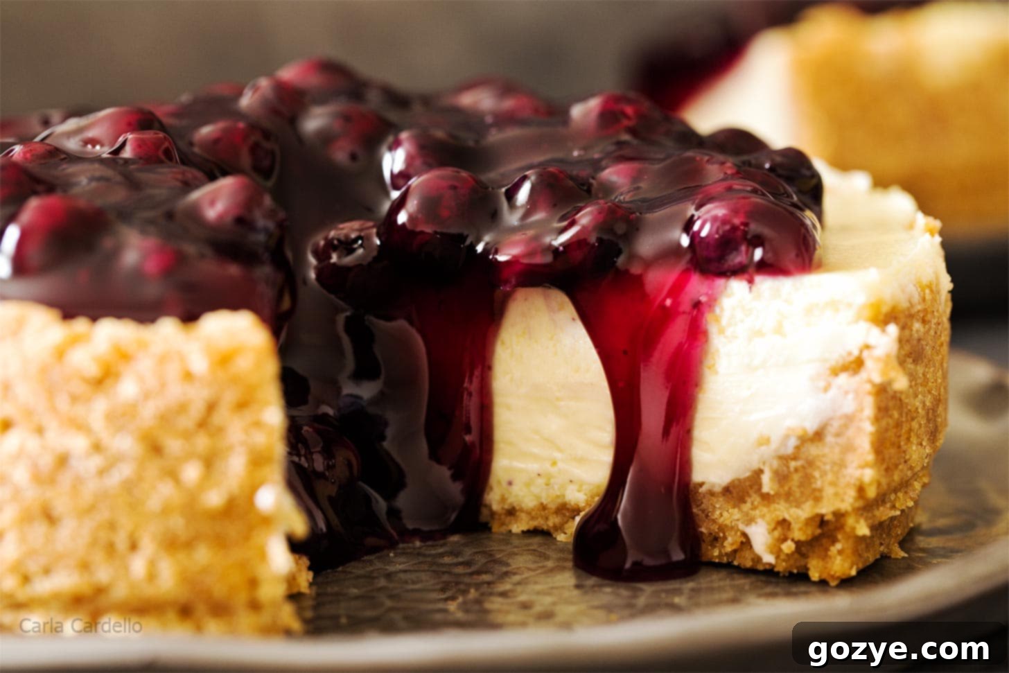Close-up shot of a 7 inch cheesecake with a single slice removed, revealing the perfect interior.