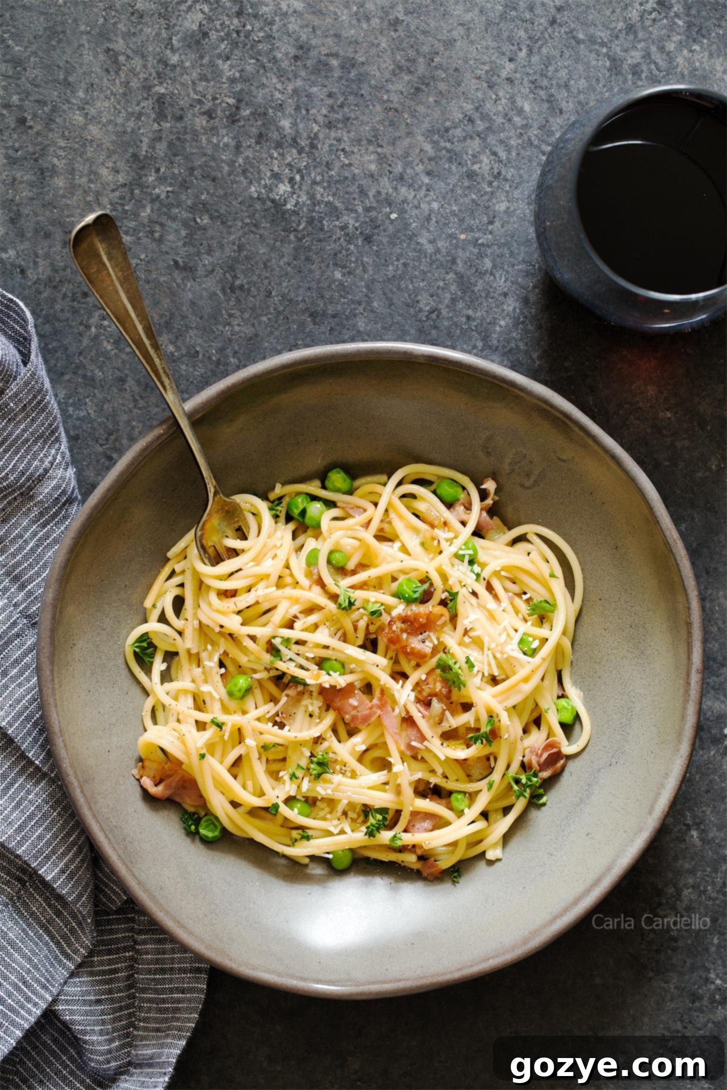 Prosciutto pasta in grey bowl with fork