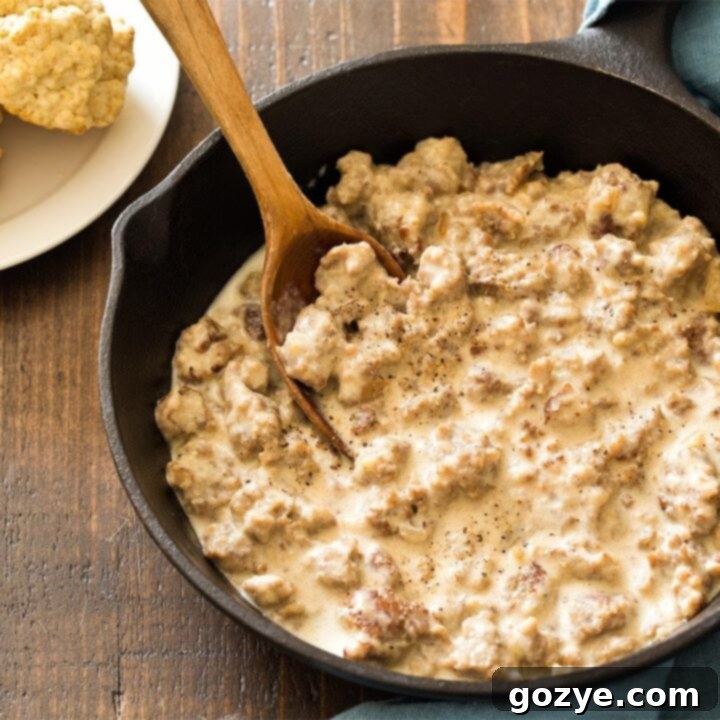 Sausage gravy cooked in cast iron skillet, garnished and ready for serving