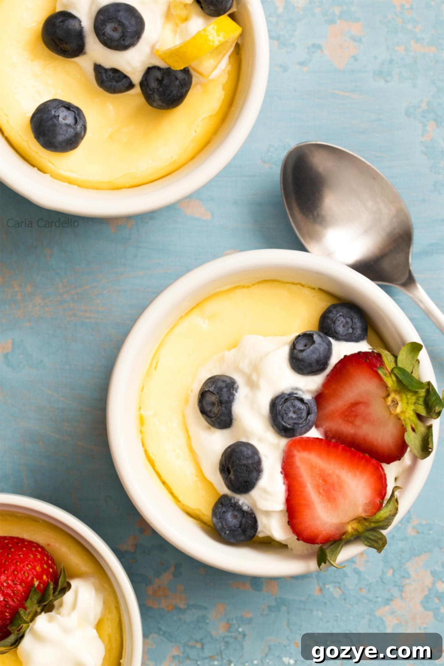 Air Fryer Cheesecake in ramekins with whipped cream and berries