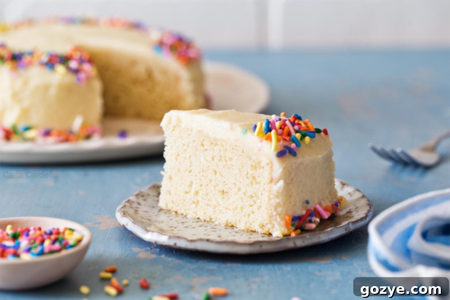 A clean slice of a 6-inch vanilla cake, revealing the soft, fluffy interior and creamy frosting.