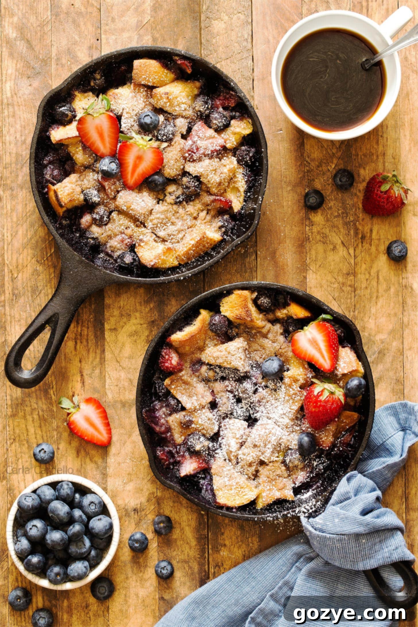 Cozy French Toast Casserole for Two 2 Two mini cast iron skillets filled with French Toast Casserole for two, garnished with fresh berries and powdered sugar