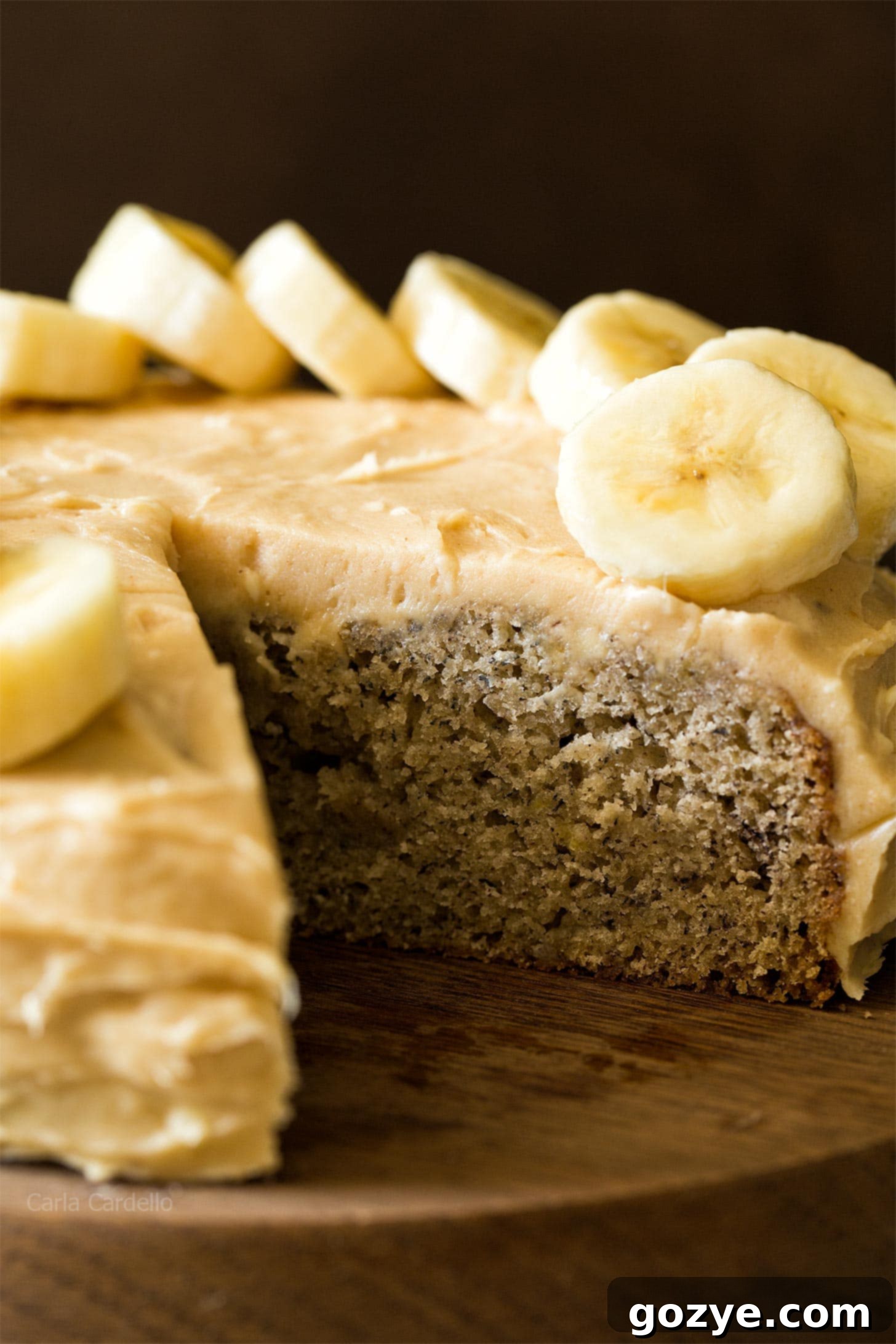 Close up view of the small banana cake, richly frosted with cream cheese frosting, ready for serving