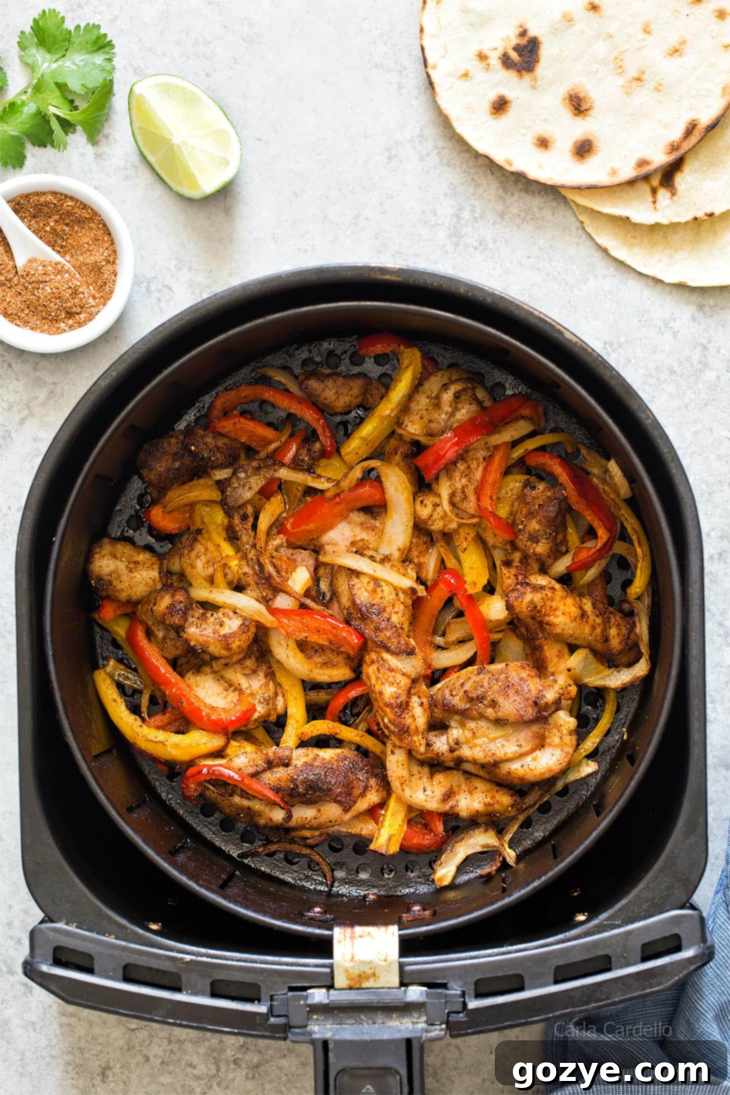 Crispy Air Fryer Chicken Fajitas in a basket with bell peppers and onions