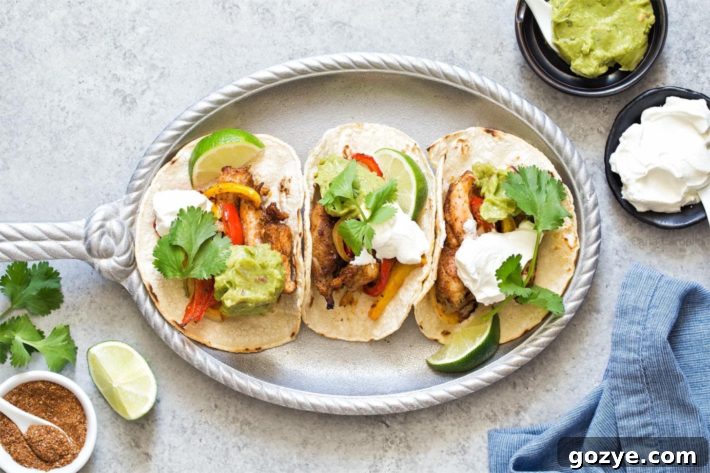 Finished Air Fryer Chicken Fajitas in corn tortillas, garnished on a silver plate