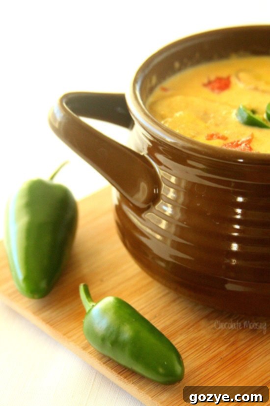 A bowl of creamy Roasted Jalapeno Soup garnished with fresh herbs