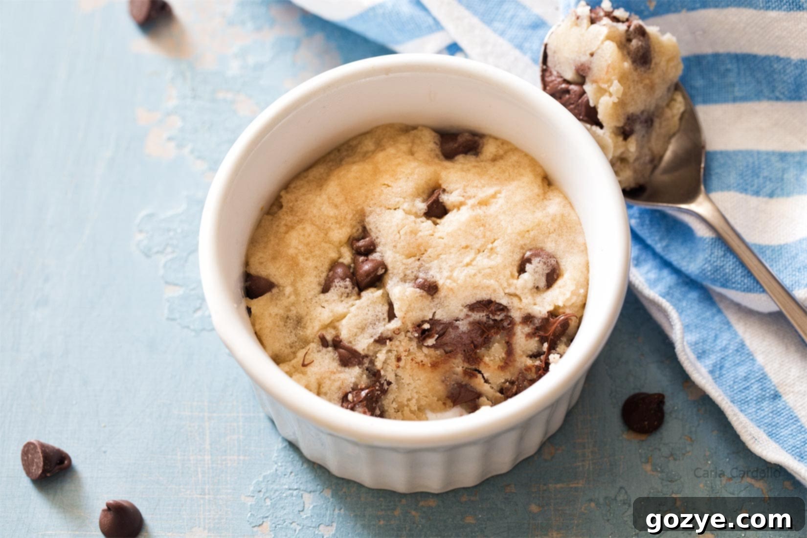 Microwave chocolate chip cookie in a ramekin with a bite taken out, showing the soft and chewy texture