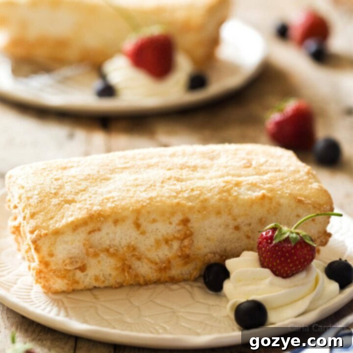 Mini Angel Food Cake on white plate with whipped cream and berries