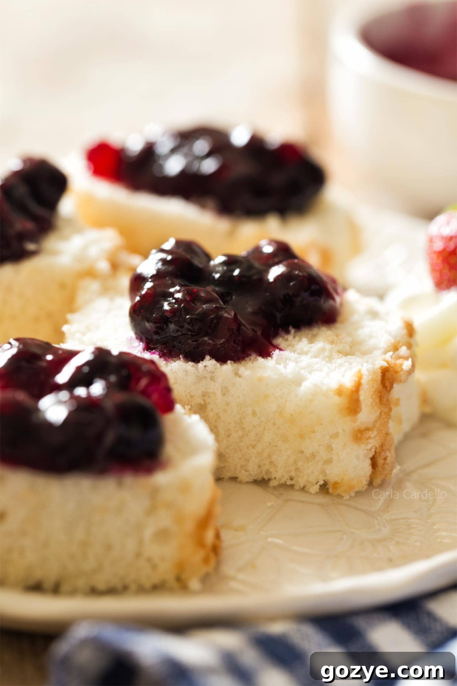 Mini angel food cake garnished with homemade blueberry pie filling and a fresh mint leaf