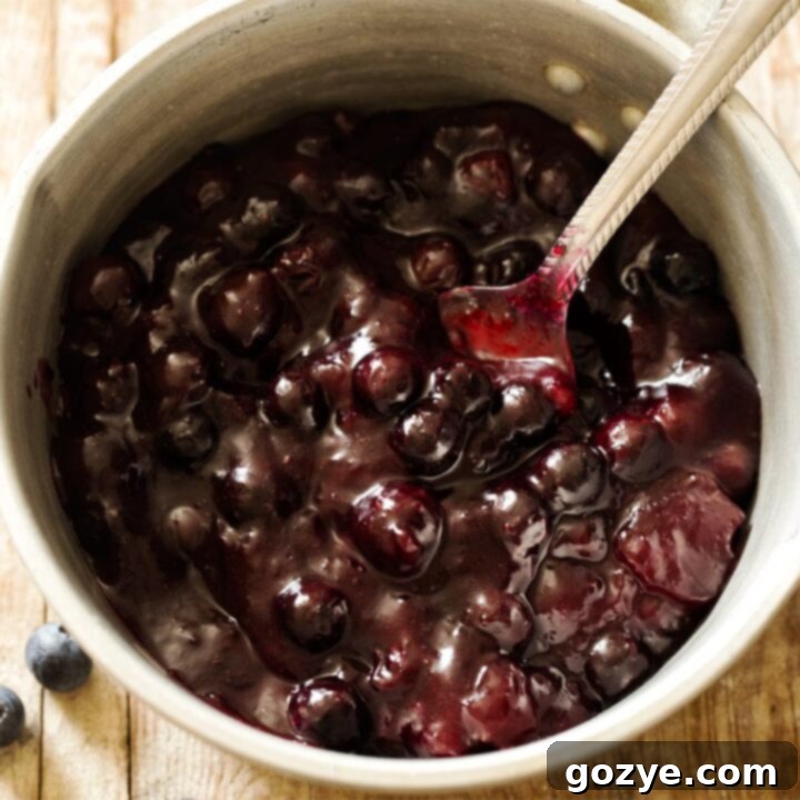 Homemade blueberry pie filling in a saucepan with a spoon, ready to be used in desserts