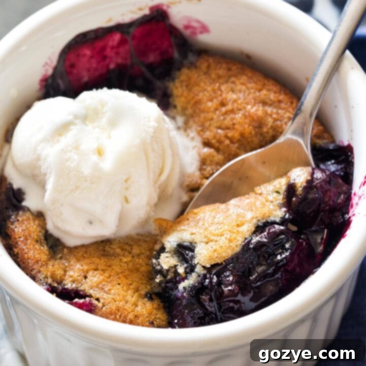Close up of spoon serving blueberry cobbler