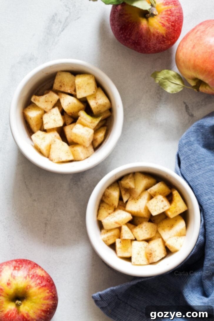 Diced apple filling perfectly arranged in two white ramekins, ready for the streusel topping
