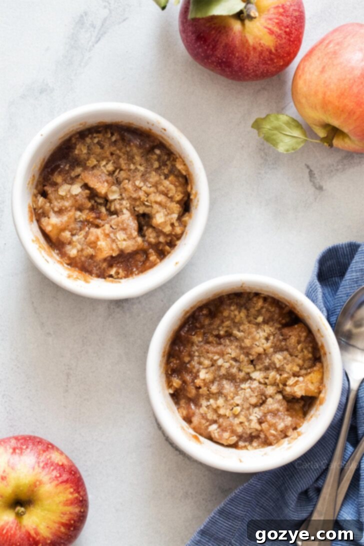 Freshly baked apple crisp, golden brown and bubbly from the oven, served in a white ramekin
