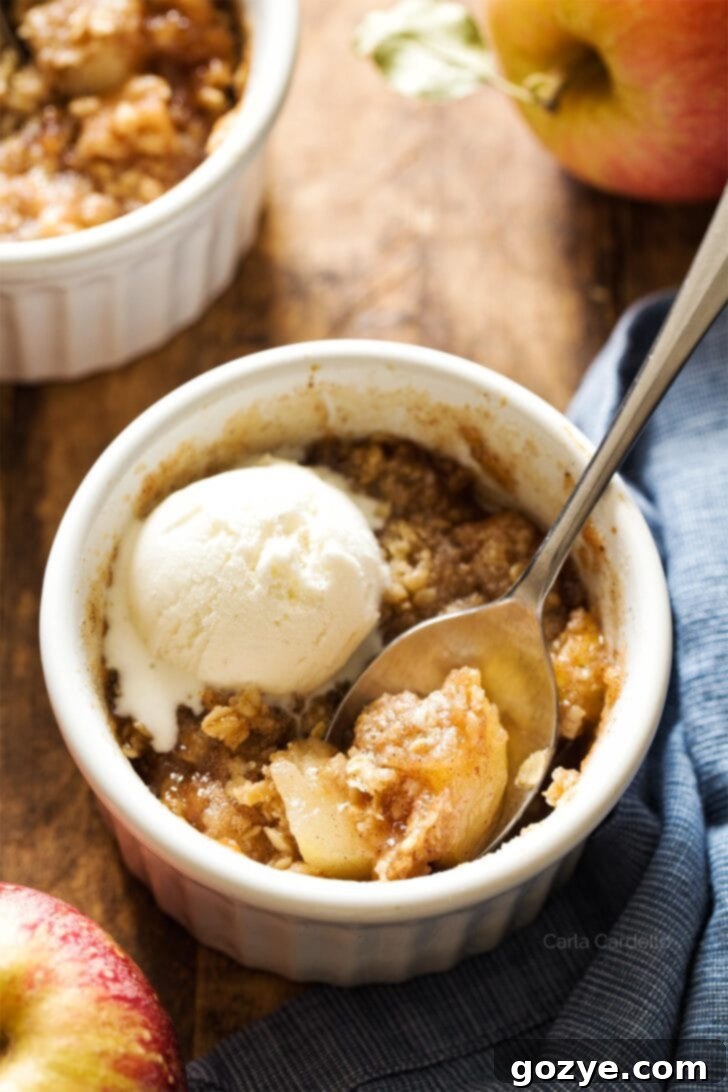 Apple crisp in white ramekin with spoon, ready to be enjoyed