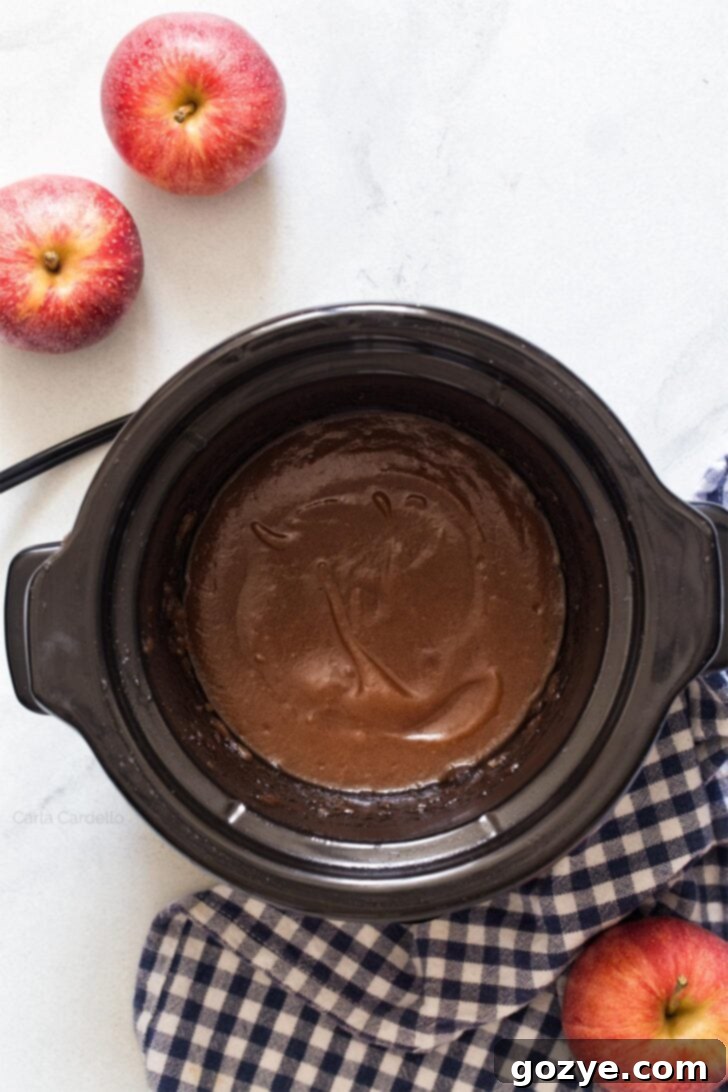 Smooth, blended apple butter in a slow cooker after processing, ready for its final cook down.