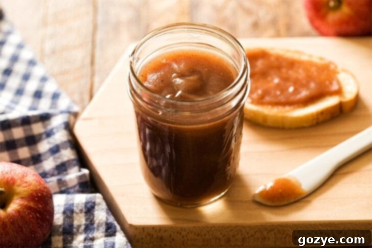 A beautifully presented jar of homemade apple butter, emphasizing its appeal as a gift or pantry staple.