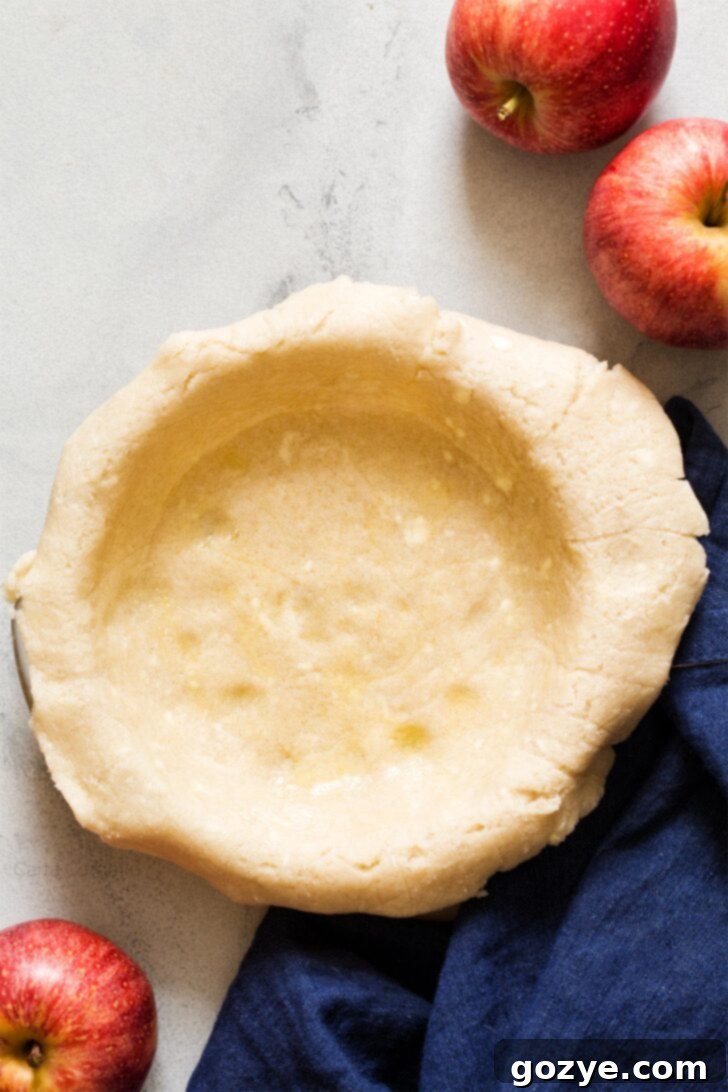Pie dough perfectly fitted inside a 6-inch pie plate, ready for filling.
