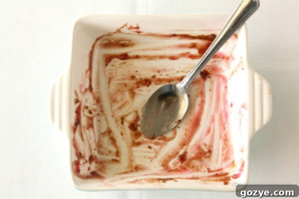 A slice of Peach and Cherry Gingerbread Cobbler topped with vanilla ice cream.