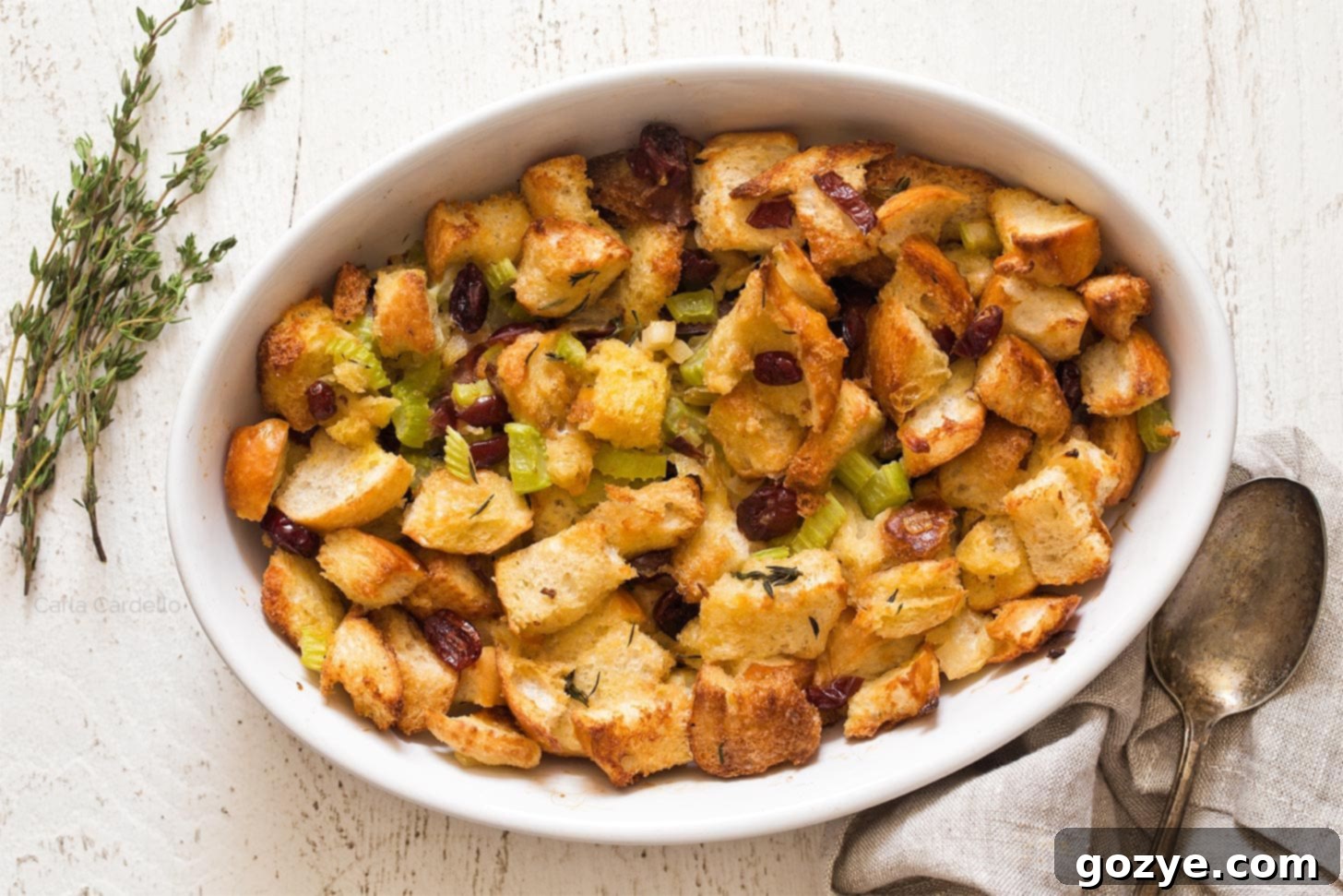 Serving of cranberry stuffing on a plate with blurred Thanksgiving dinner background