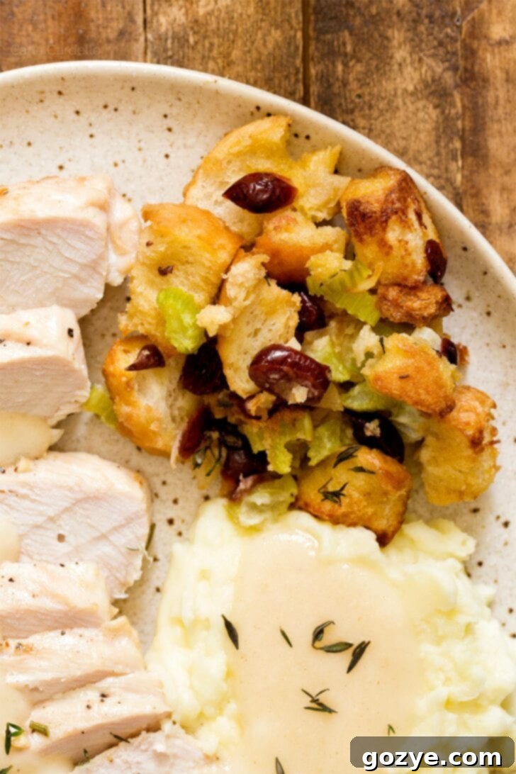 Plate with Thanksgiving dinner featuring cranberry stuffing, turkey, and green beans
