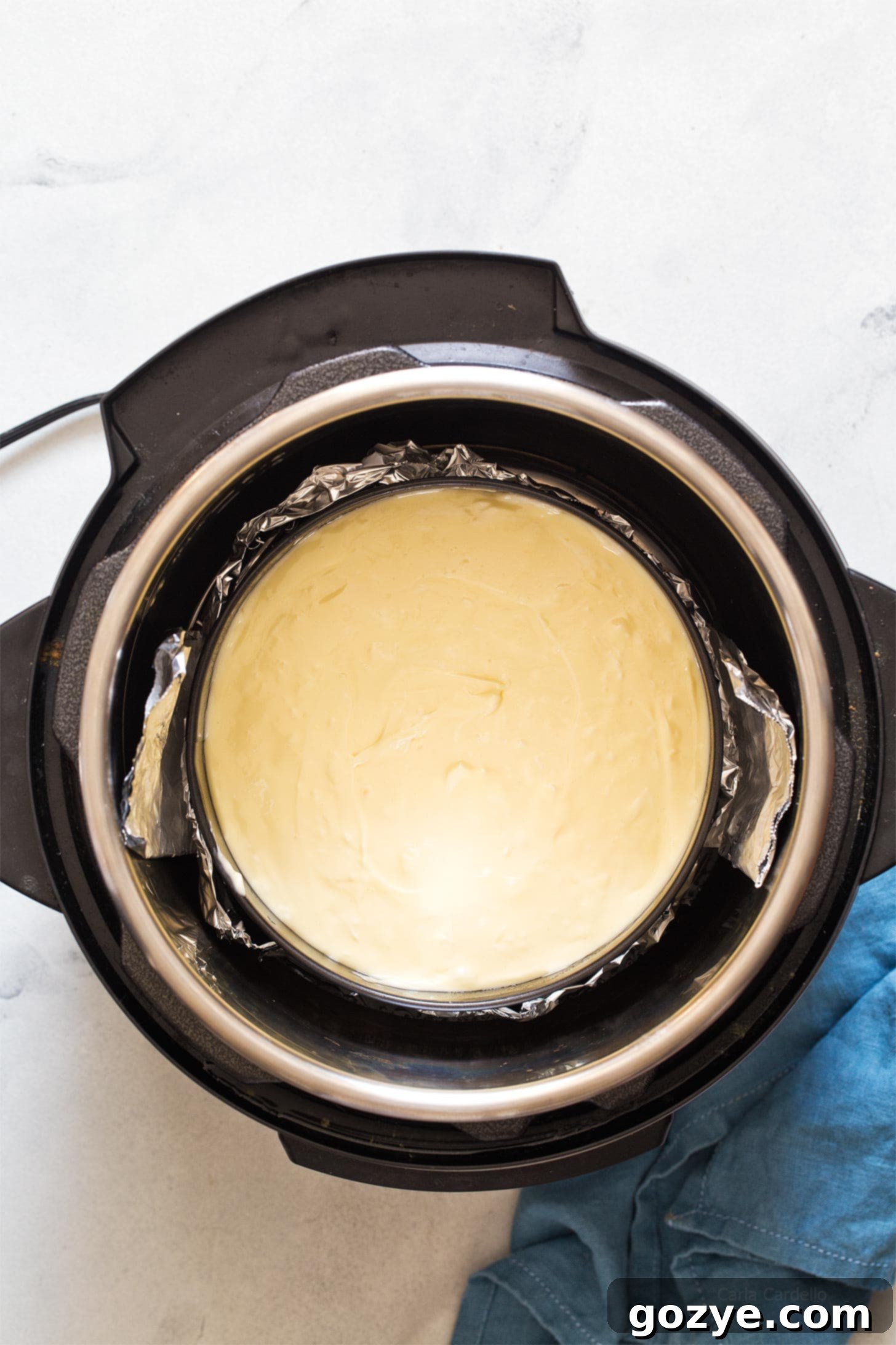 Setting up the cheesecake pan in the Instant Pot with a foil sling.