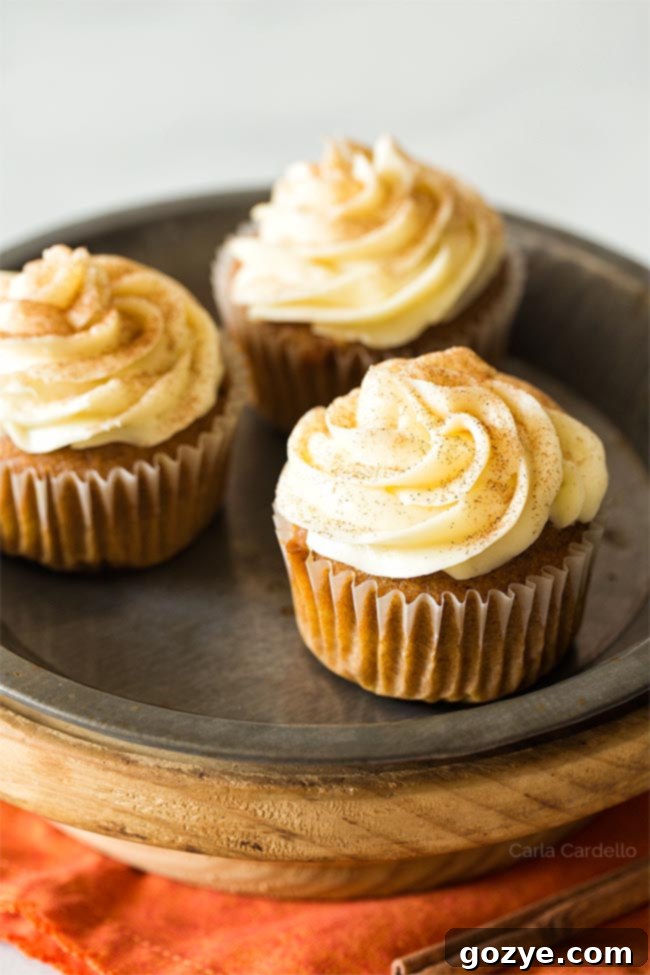 Three pumpkin cupcakes on a plate, ready to be frosted and enjoyed.
