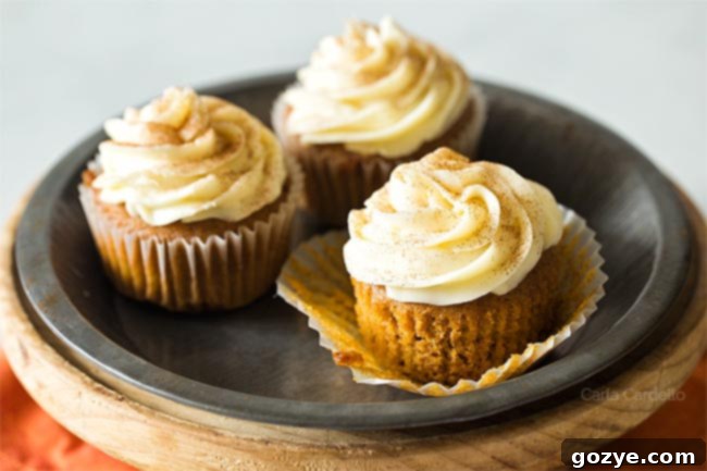 Pumpkin Cupcake with paper liner peeled off, showing its golden-brown exterior and inviting texture.