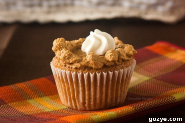 Pumpkin cupcake skillfully decorated to resemble a miniature pumpkin pie, complete with a piped crust.