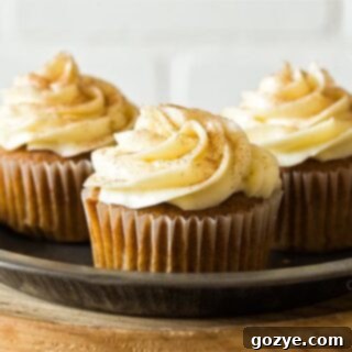 Three pumpkin cupcakes on a plate, presented with delicious frosting.