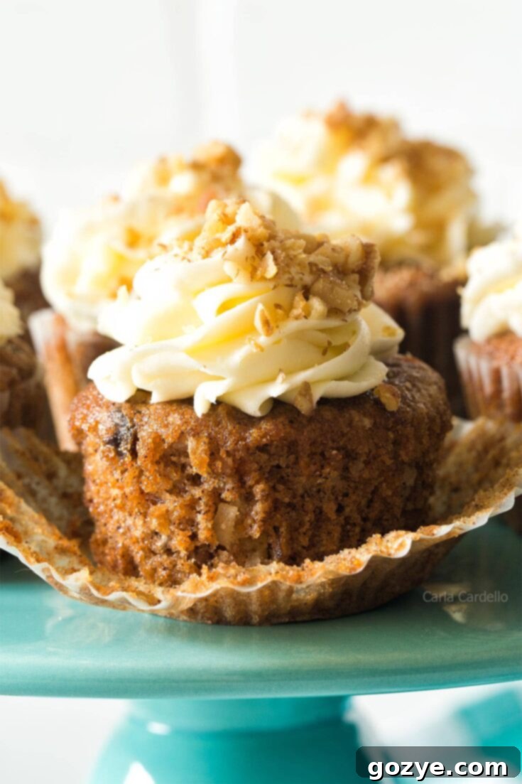 Carrot cake cupcakes with pineapple, coconut, walnuts, and raisins.