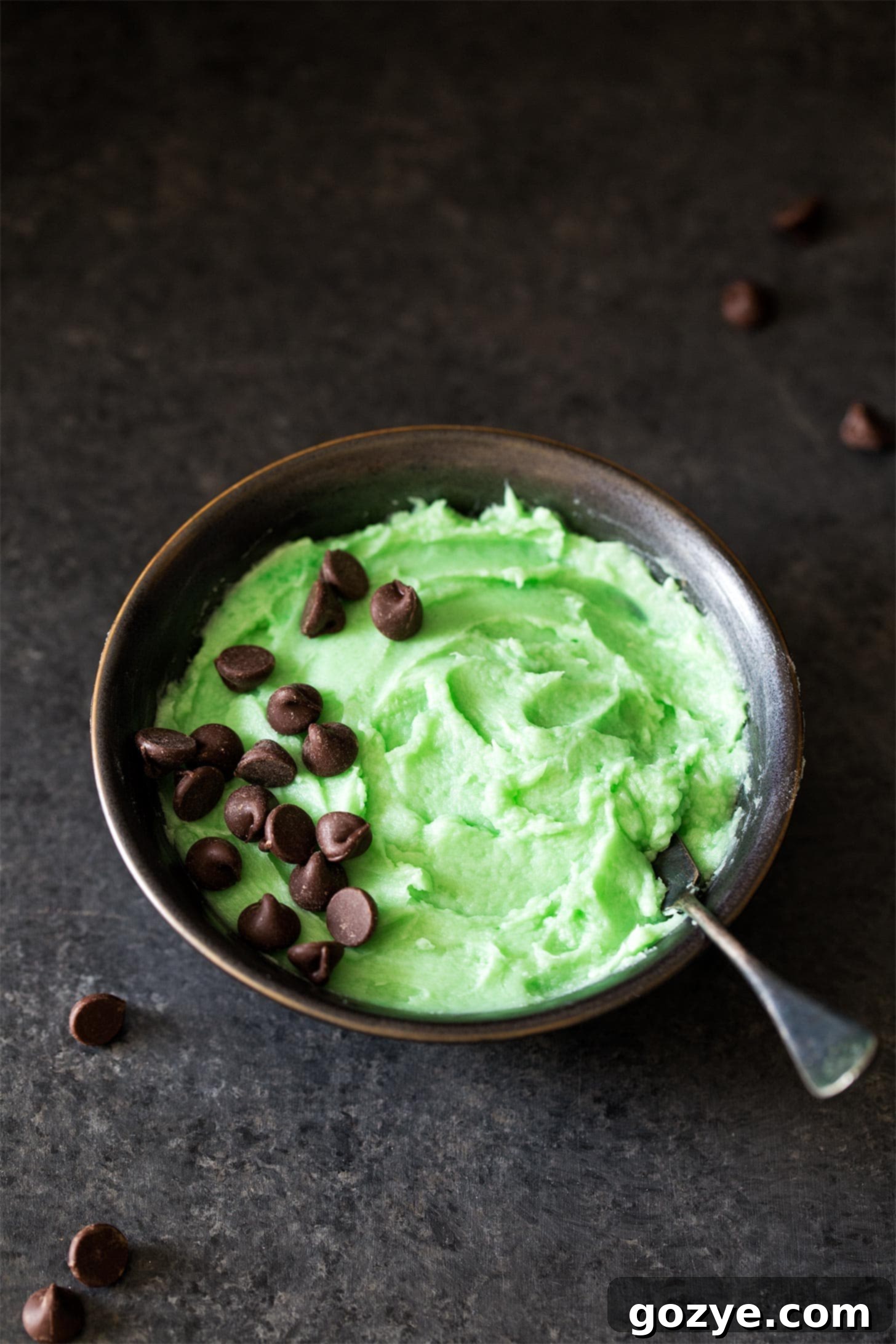 Mint Buttercream in a bowl with a knife, showcasing its creamy texture.