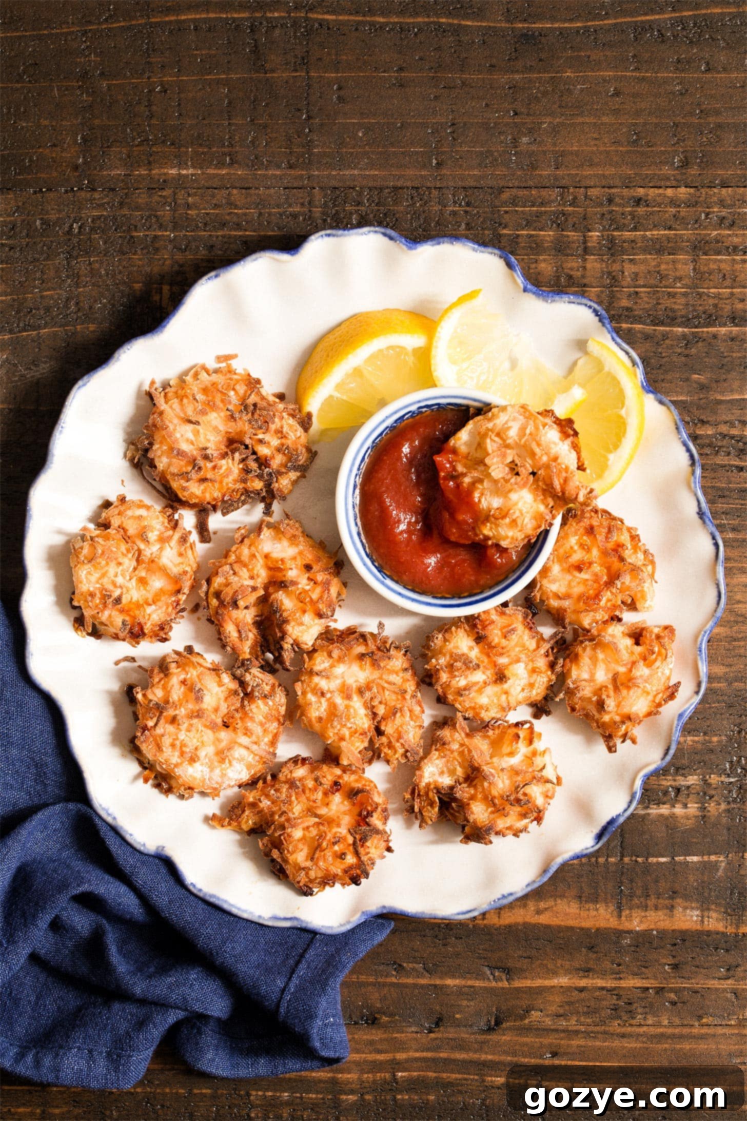 Coconut shrimp in air fryer on white ruffled plate