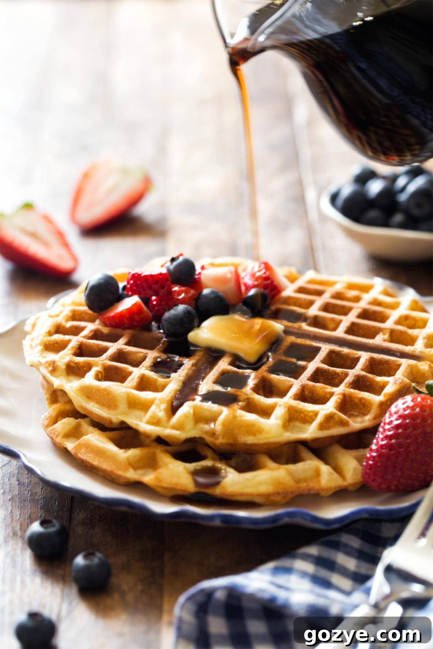 Pouring syrup on top of waffles for two