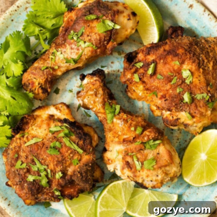 Crispy Air Fryer Fried Chicken on a blue plate, garnished with lime and cilantro, showcasing its golden perfection.
