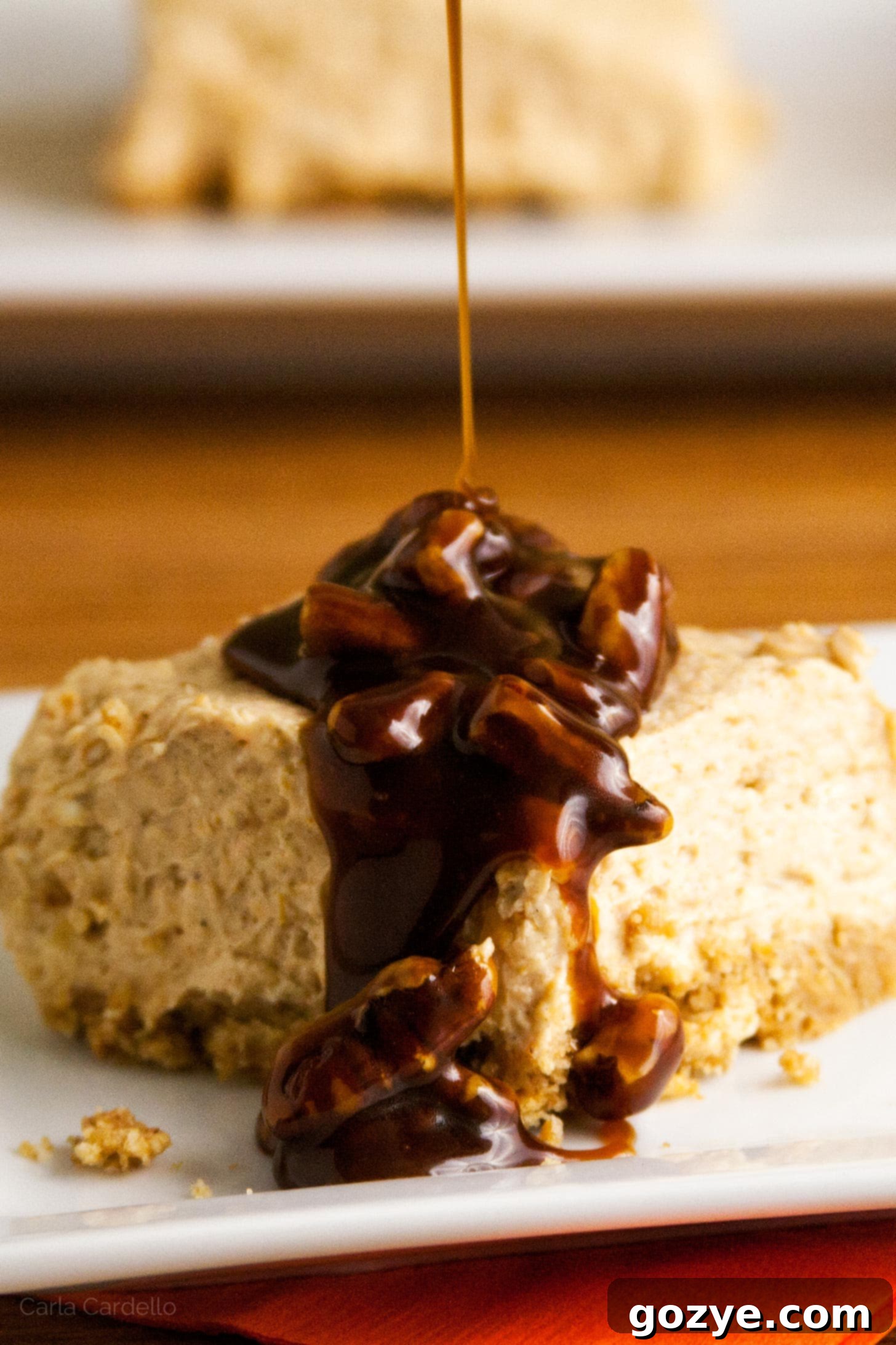 Effortless Pumpkin Cheesecake Squares 5 Pouring praline sauce on top of pumpkin cheesecake bars