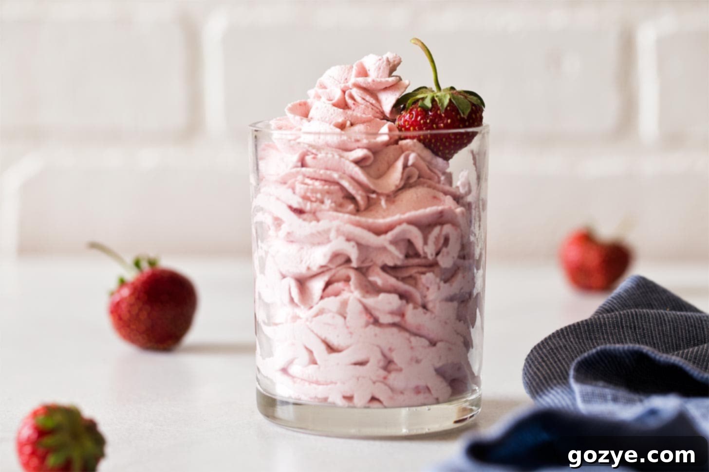 Whipped strawberry frosting piped into a glass