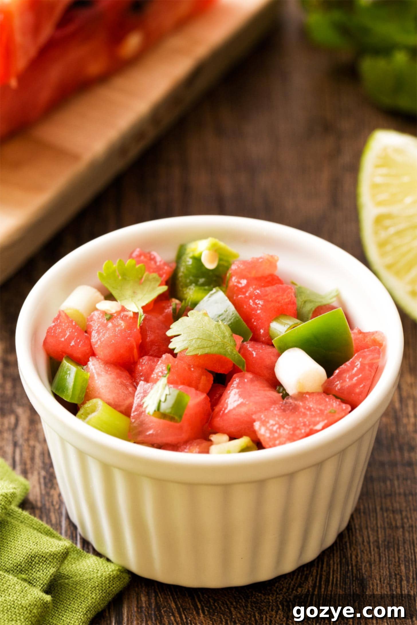 Close-up of Watermelon Salsa in a small white ramekin, showing diced watermelon, green onion, and cilantro