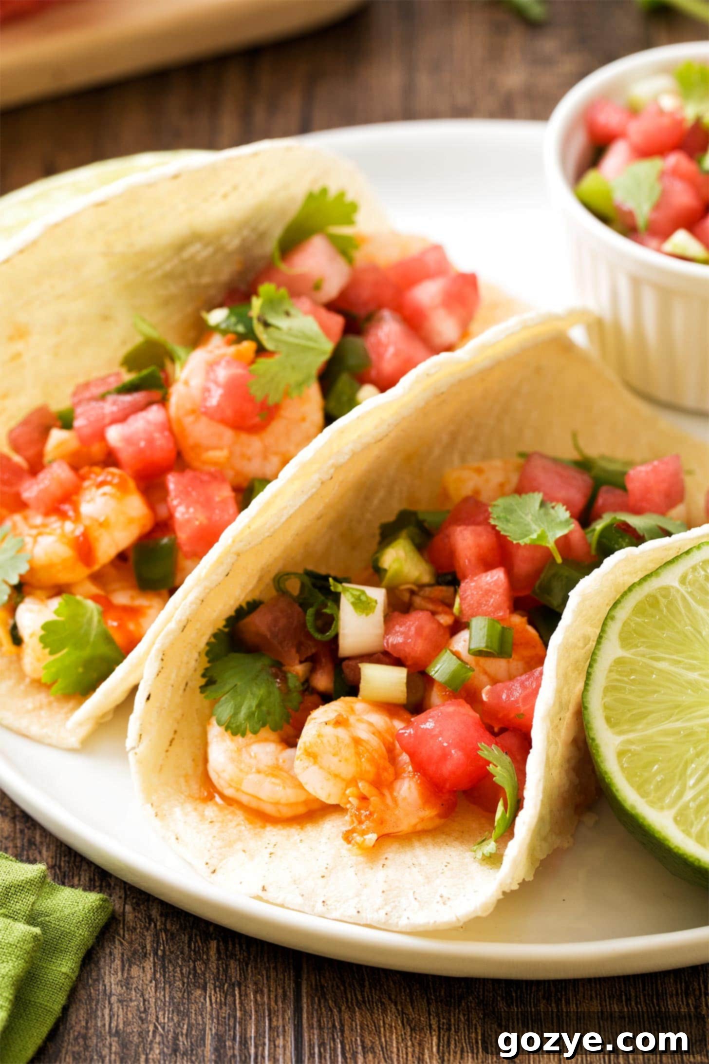 Watermelon Salsa generously topped on spicy shrimp tacos, with cilantro garnish