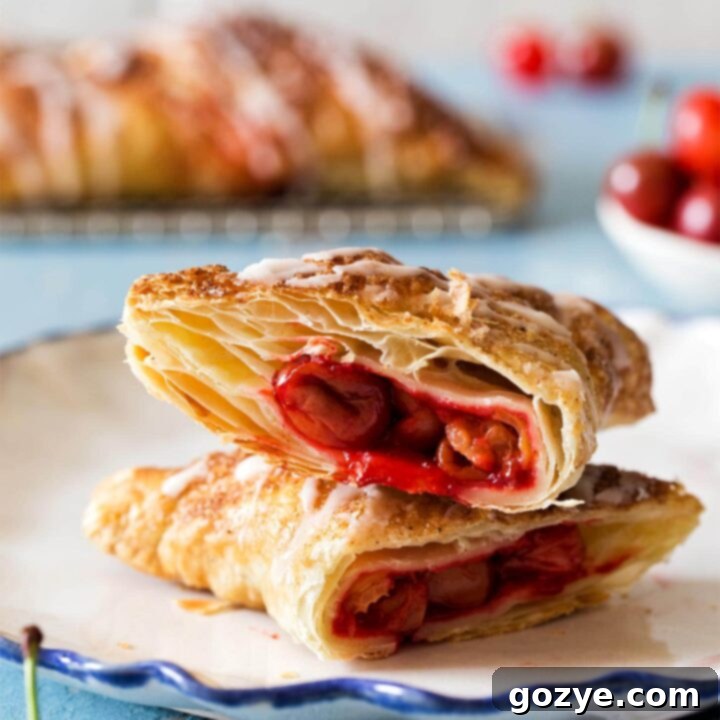 Cherry Turnovers with puff pastry stacked on a white plate