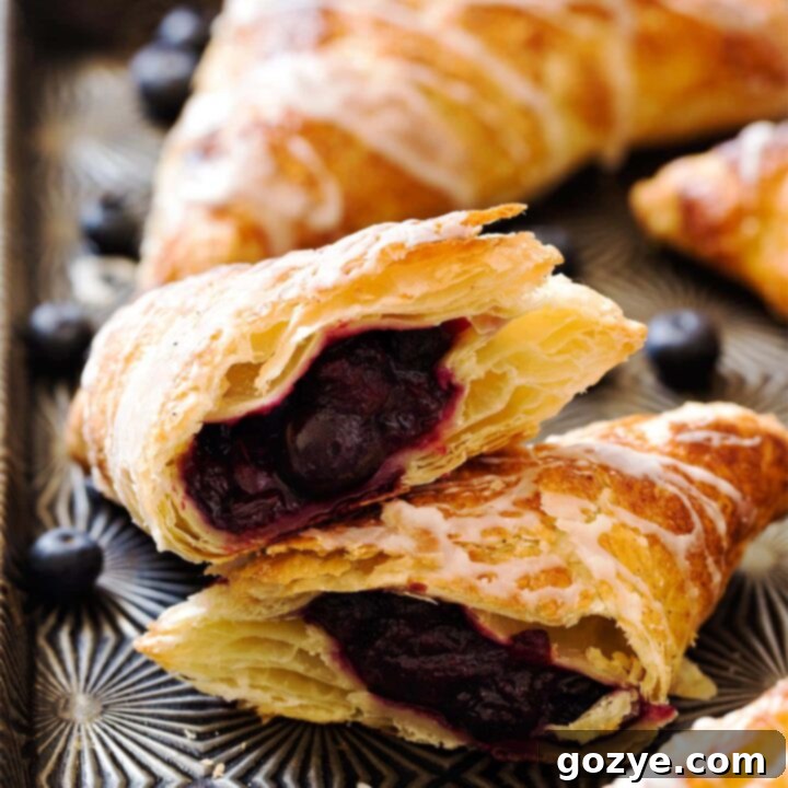 Puff Pastry Blueberry Turnovers cut in half to show blueberry pie filling