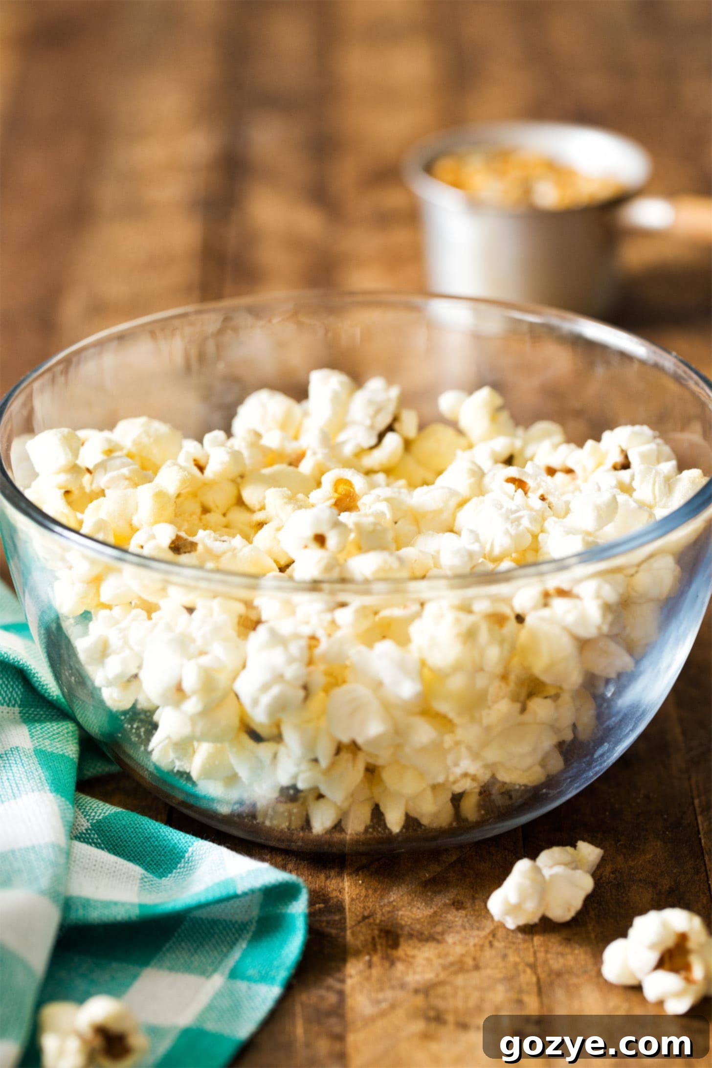 A glass bowl overflowing with golden, freshly popped homemade popcorn, highlighting its fluffy texture.