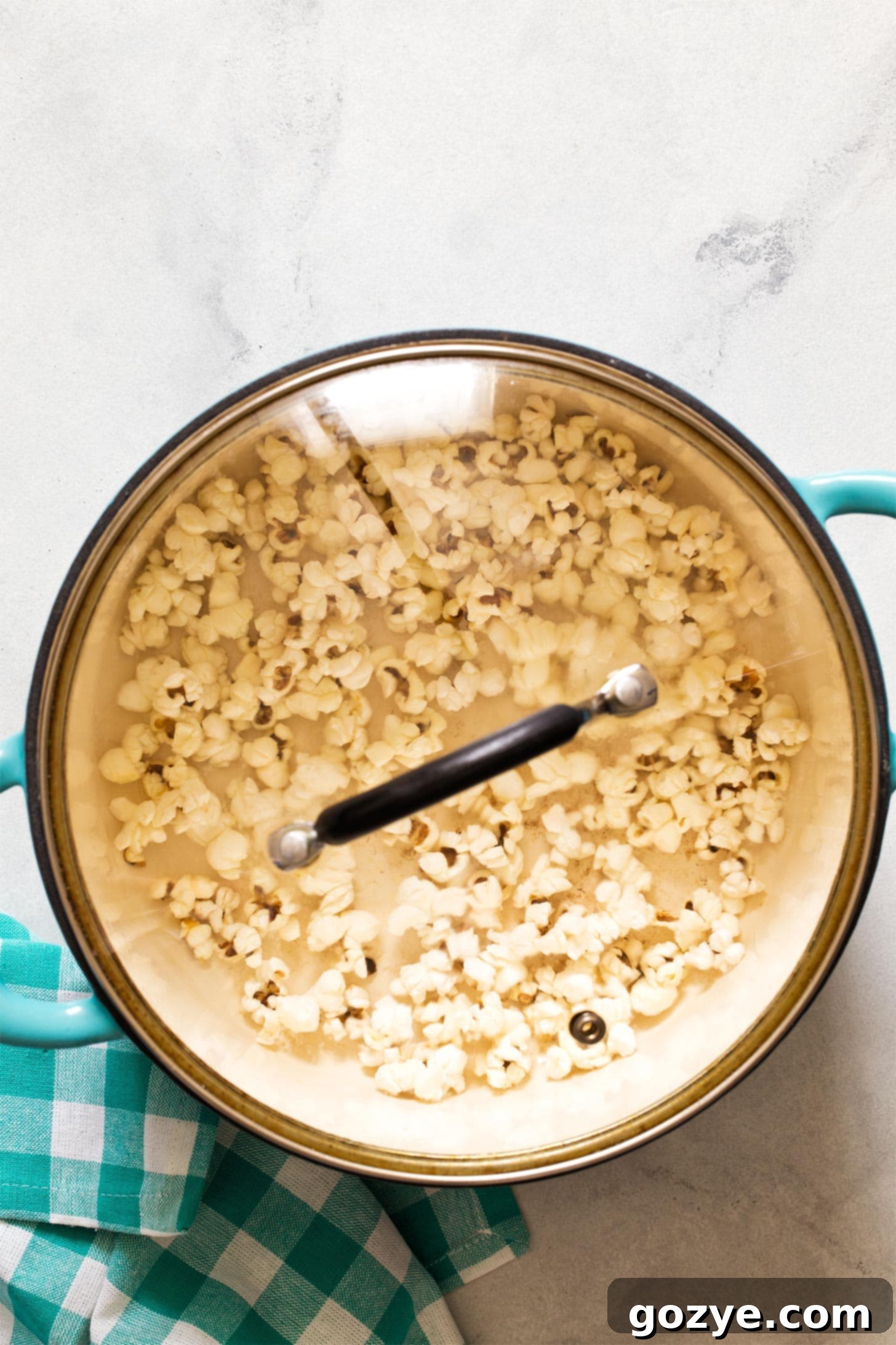 A pot with a lid slightly ajar on a stovetop, with popcorn popping inside, illustrating steam release.