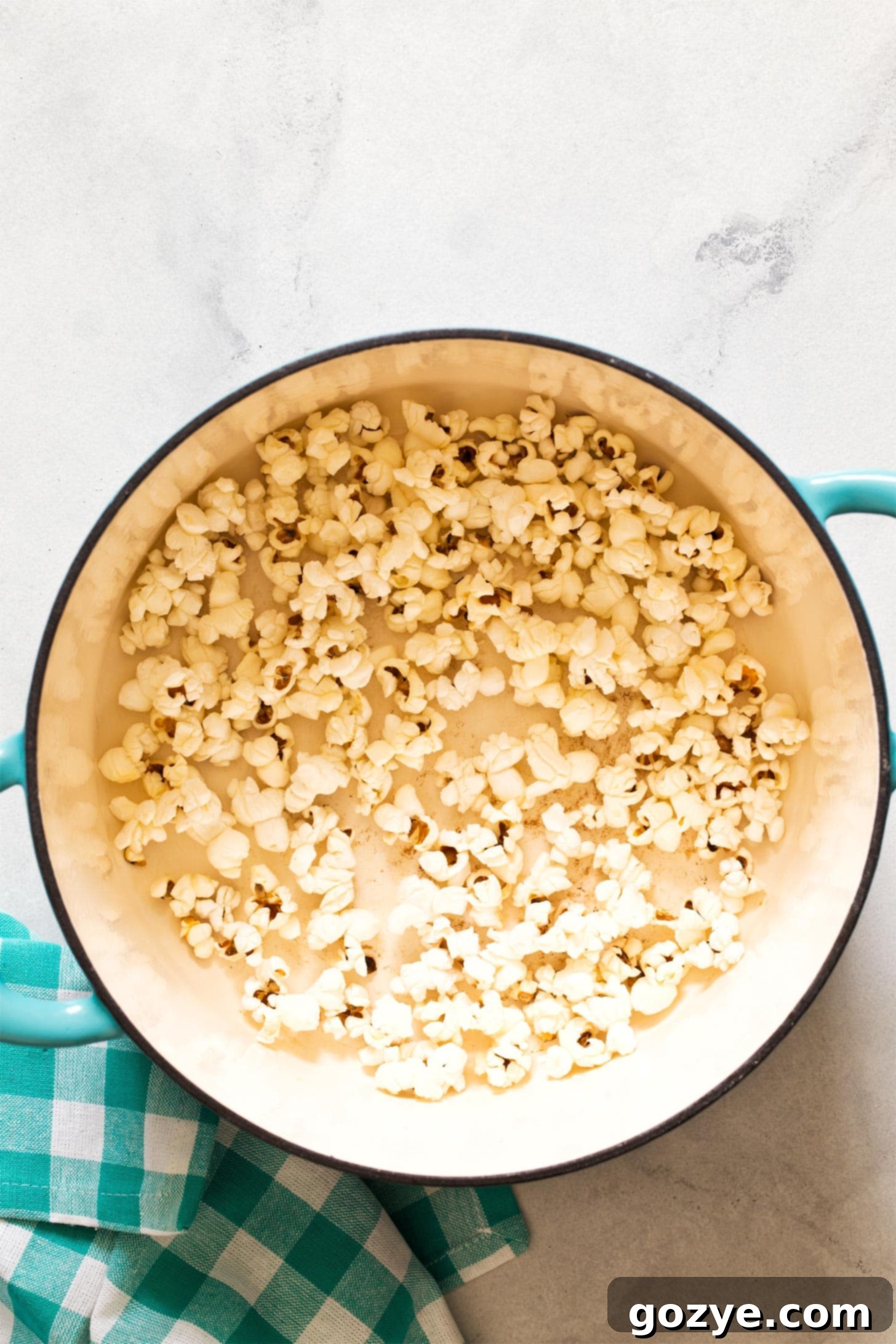 A large pot filled with freshly popped homemade popcorn, ready to be seasoned and served.
